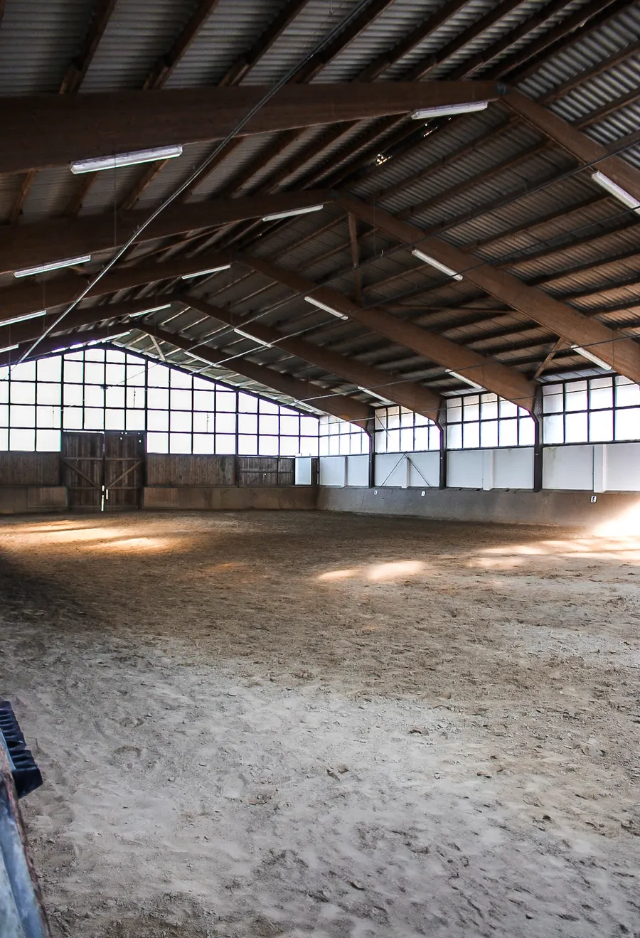 Innenansicht der Reithalle mit Holzbindern